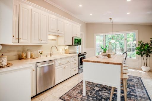 The kitchen features a center island, breakfast bar, eat-in dining area, and bay window.