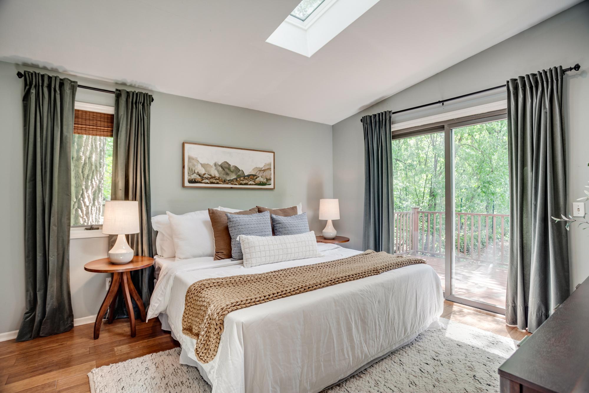 The main-level primary bedroom includes a remodeled ensuite bath and private access to the second deck.