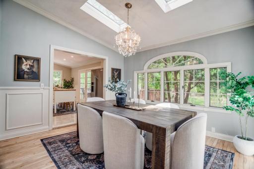 The formal dining room is flooded with natural light and leads into the kitchen.