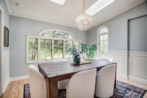 The formal dining room is flooded with natural light and leads into the kitchen.