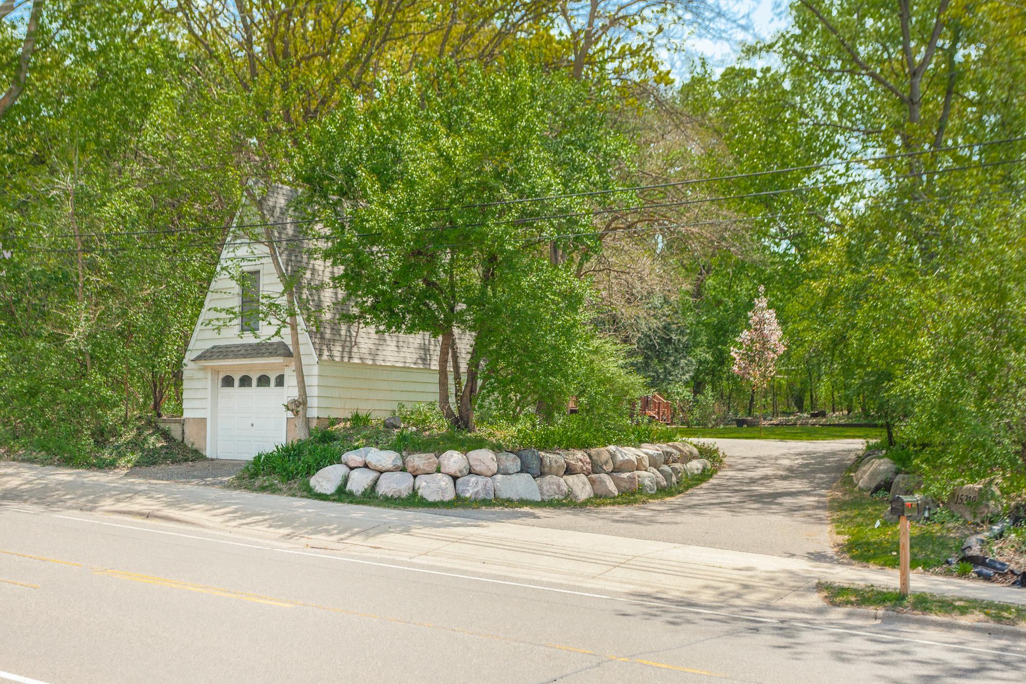 Detached third-car garage with boulder-lined entrance