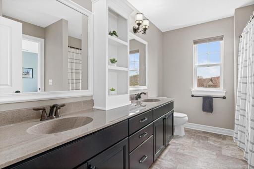 Upper level full bathroom with double vanity sinks and great storage.