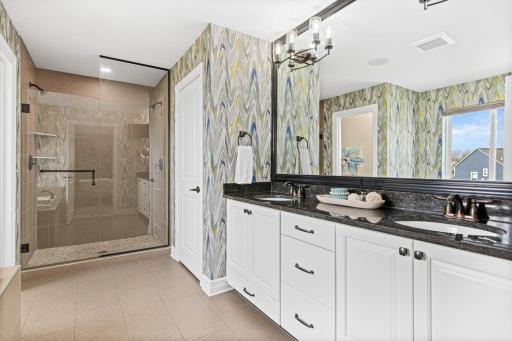 Private full primary bathroom suite including double vanity sinks and extra storage space.