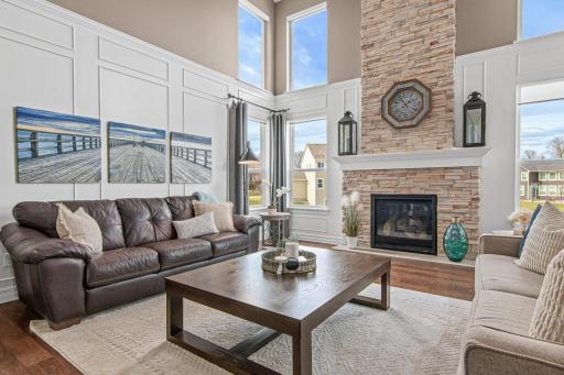 Two-story fireplace with walls of windows overlooking the backyard.