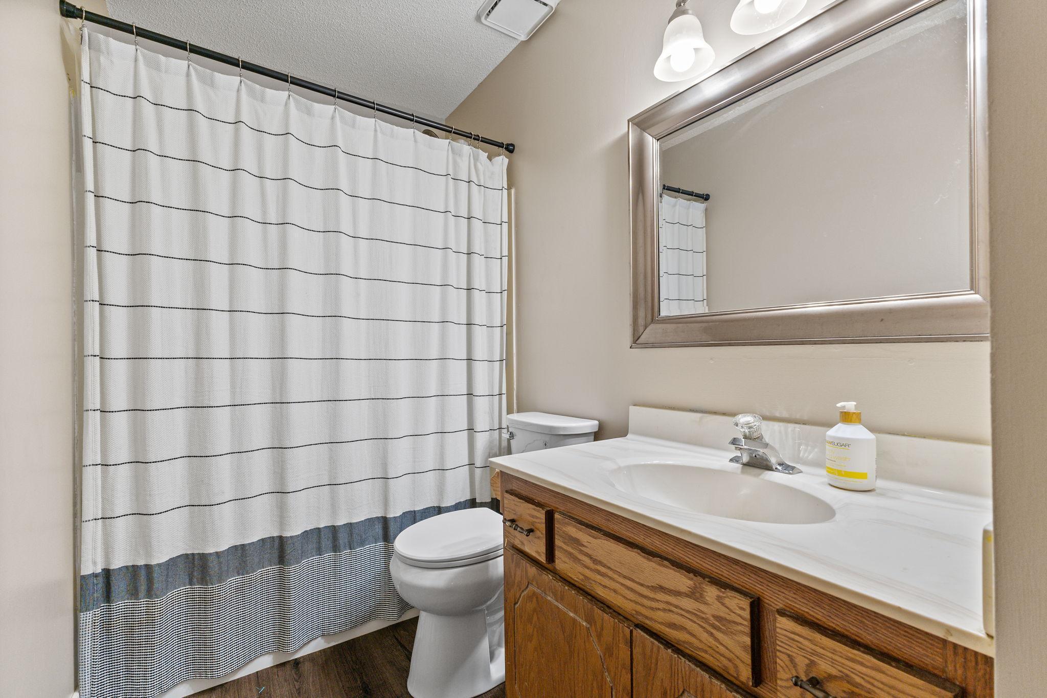 This full bathroom showcases new flooring and fresh paint for a clean and refreshed feel.