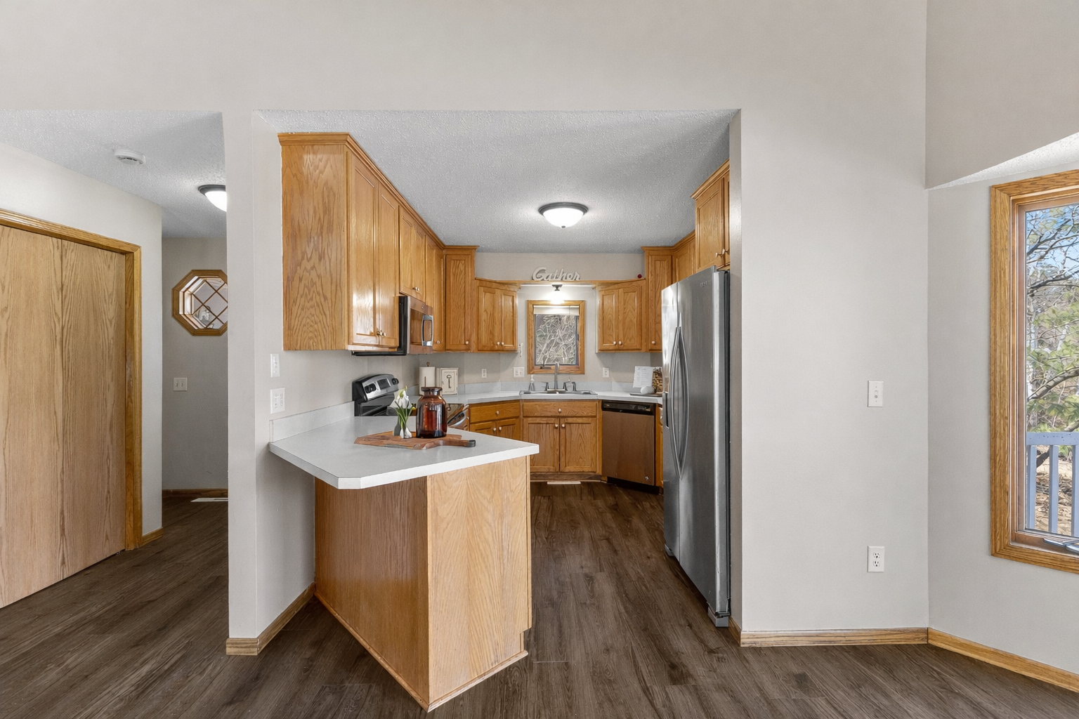 The charming kitchen features rich wooden cabinetry, stainless steel appliances, and a kitchen window.