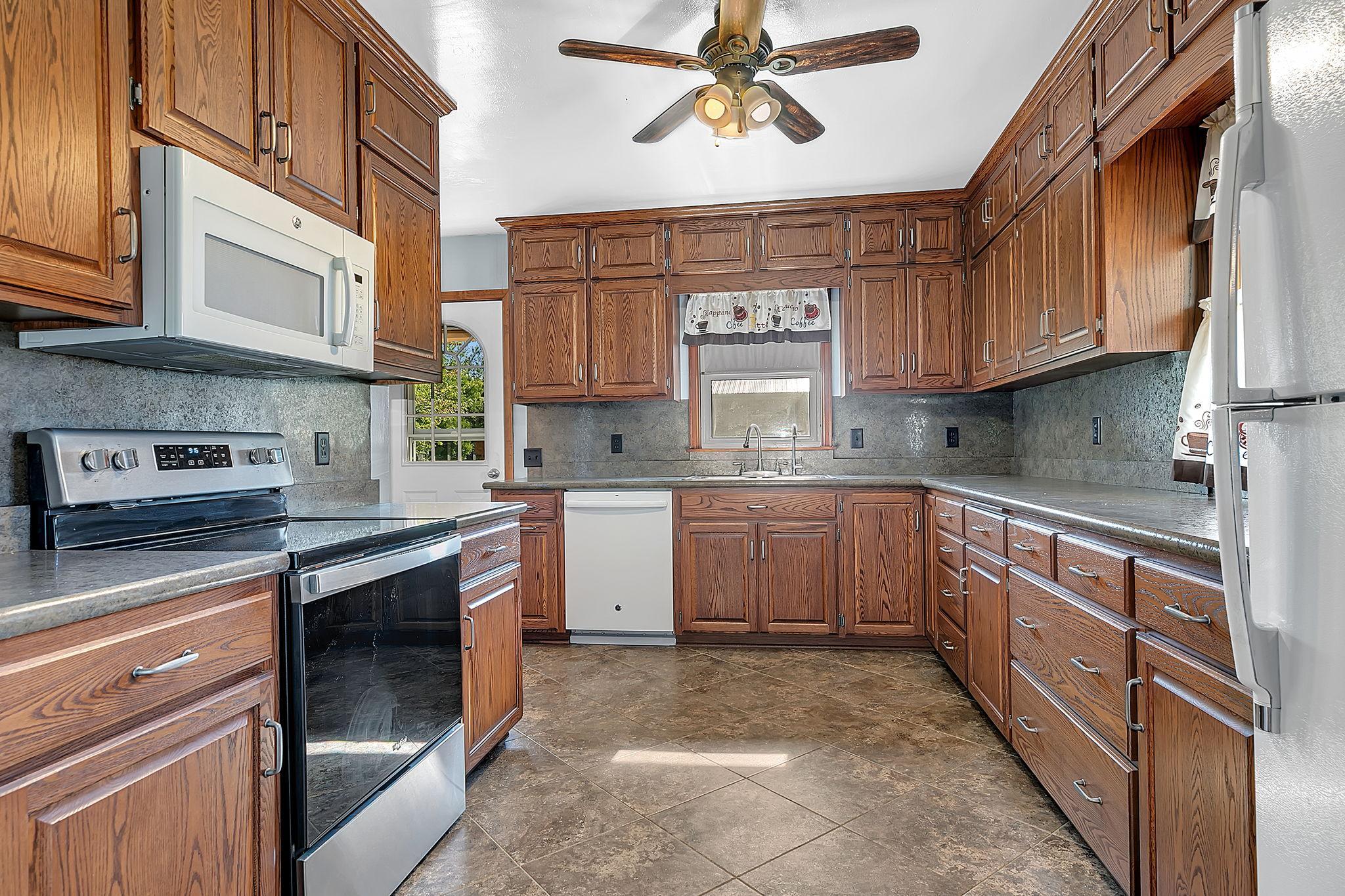 Spacious kitchen featuring oak cabinetry, generous counter space, tiled flooring with in floor heat