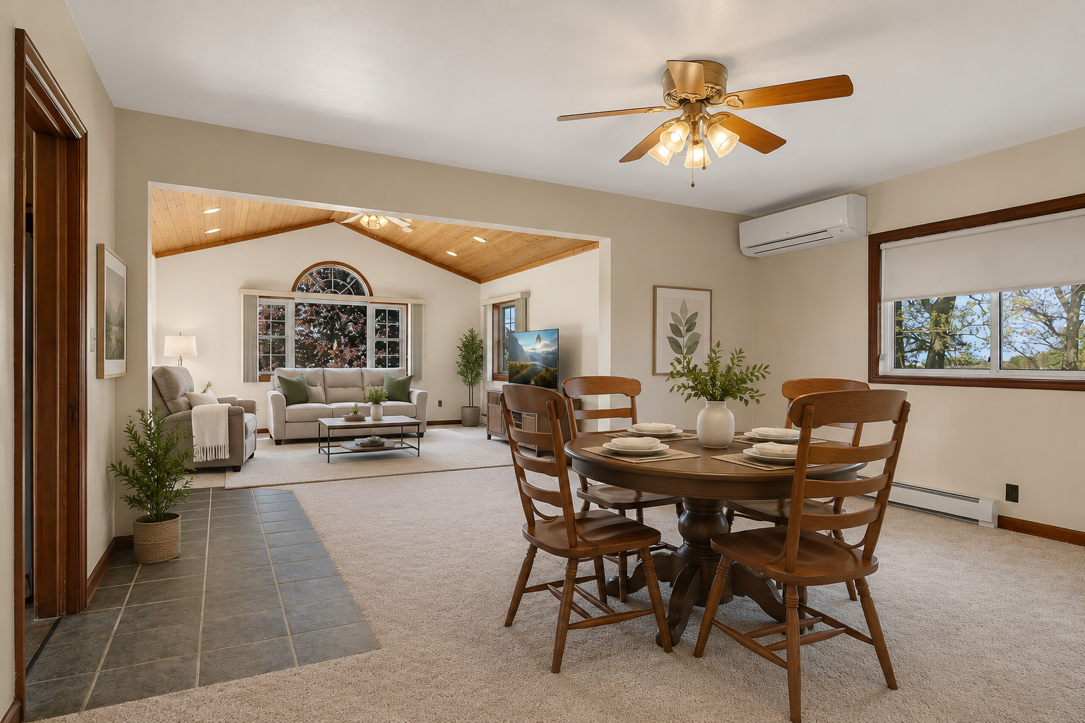 Spacious open concept living and dining area filled with natural light and warm wood accents. Vaulted tongue and groove ceiling with large windows for wonderful outdoor views. Virtually staged
