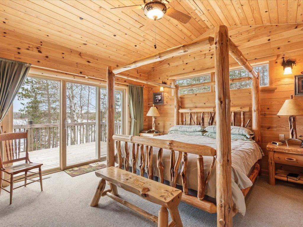 Main level primary bedroom with lakeside patio doors leading you onto deck.