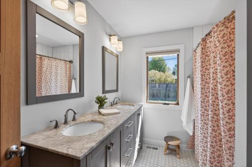 Updated full bathroom featuring dual sinks and modern finishes.