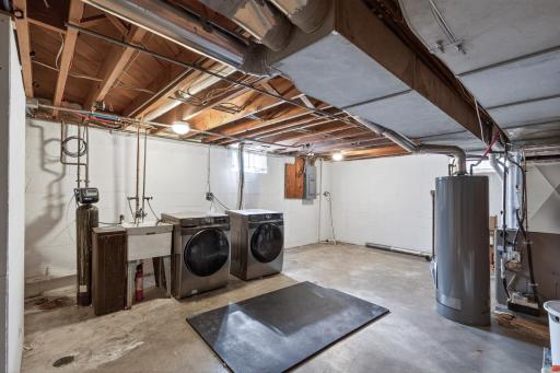 Generously sized laundry and mechanical room with utility sink and updated mechanicals.