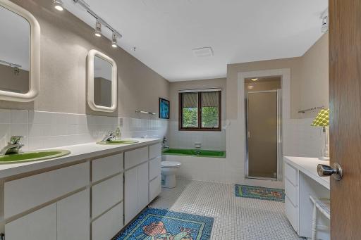 Bright and functional upper level bathroom with a practical layout, dual sinks, and easy access from both bedrooms for added convenience.