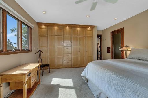 Main floor primary bedroom offers comfort, convenience, and abundant storage with custom floor to ceiling built ins.
