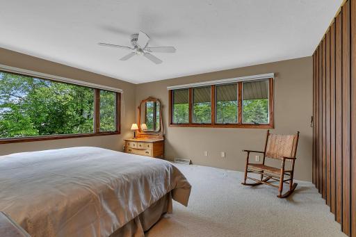 Enjoy tranquil treetop views from this inviting upper level fourth bedroom, filled with natural light and surrounded by nature.