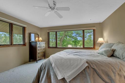 Spacious upper level third bedroom with multiple windows that bring in natural light and showcase the propertys natural surroundings.