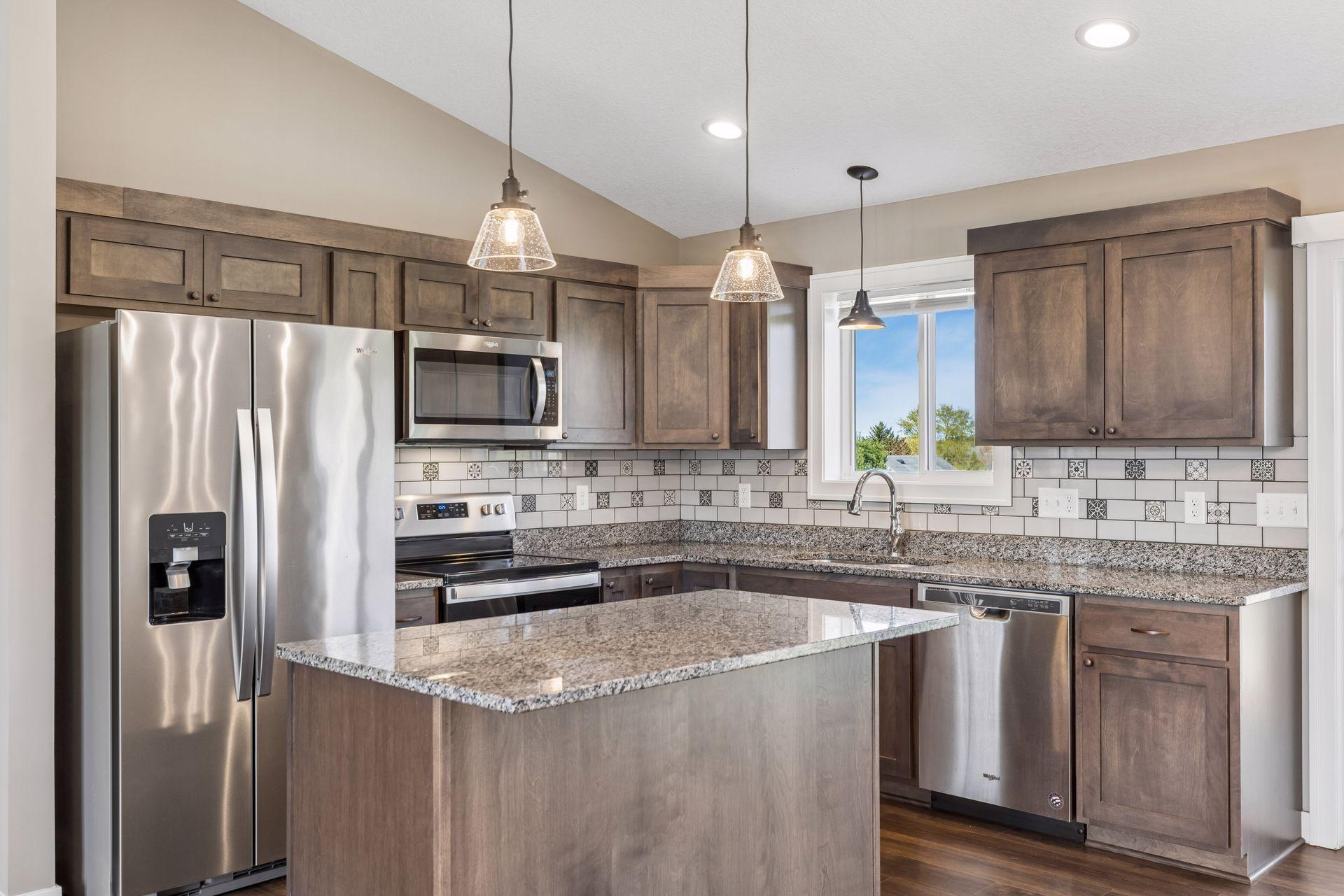 Warm wood cabinetry, tile backsplash and great lighting in the kitchen.