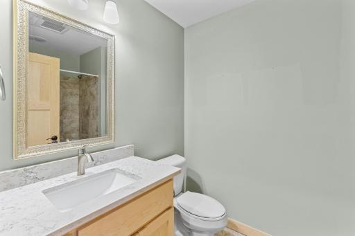 The Full Bath features a elegant tile surround, cast iron tub, and a tile floor. Complete with Maple cabinets and quartz countertops.