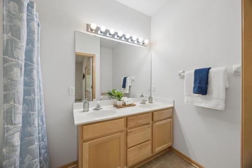 Main floor primary bath features a double vanity and jetted tub and shower
