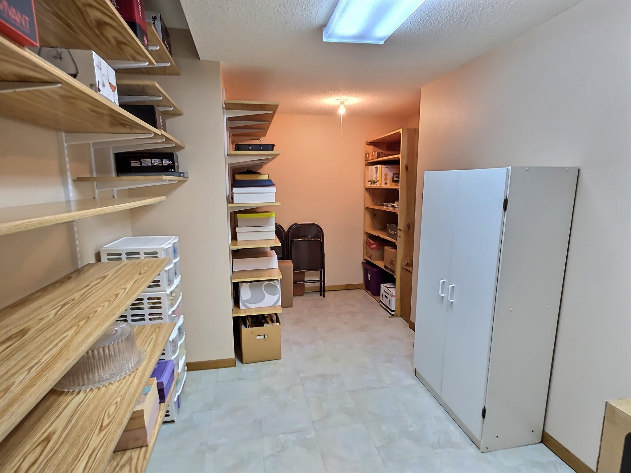 A large, well-organized basement closet offering exceptional storage capacity and smart functionality. This space is large enough for a cozy office.