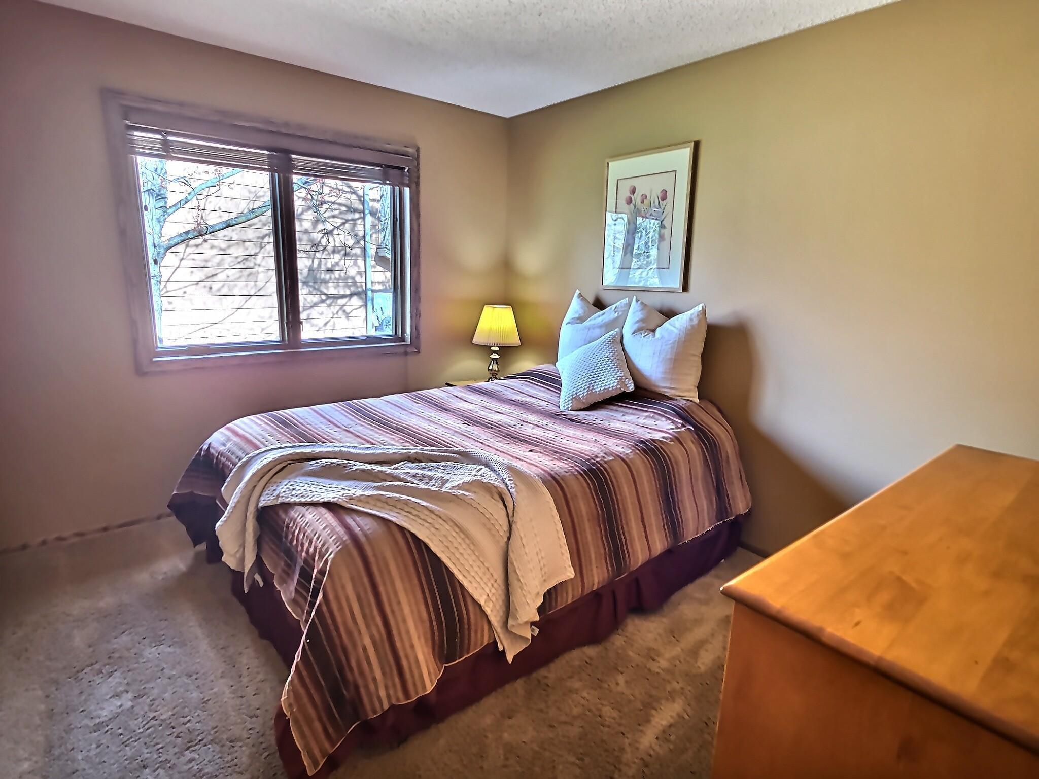 One of the three bedrooms on the upper level includes carpet floors, wooden blinds, and a nice sized closet.