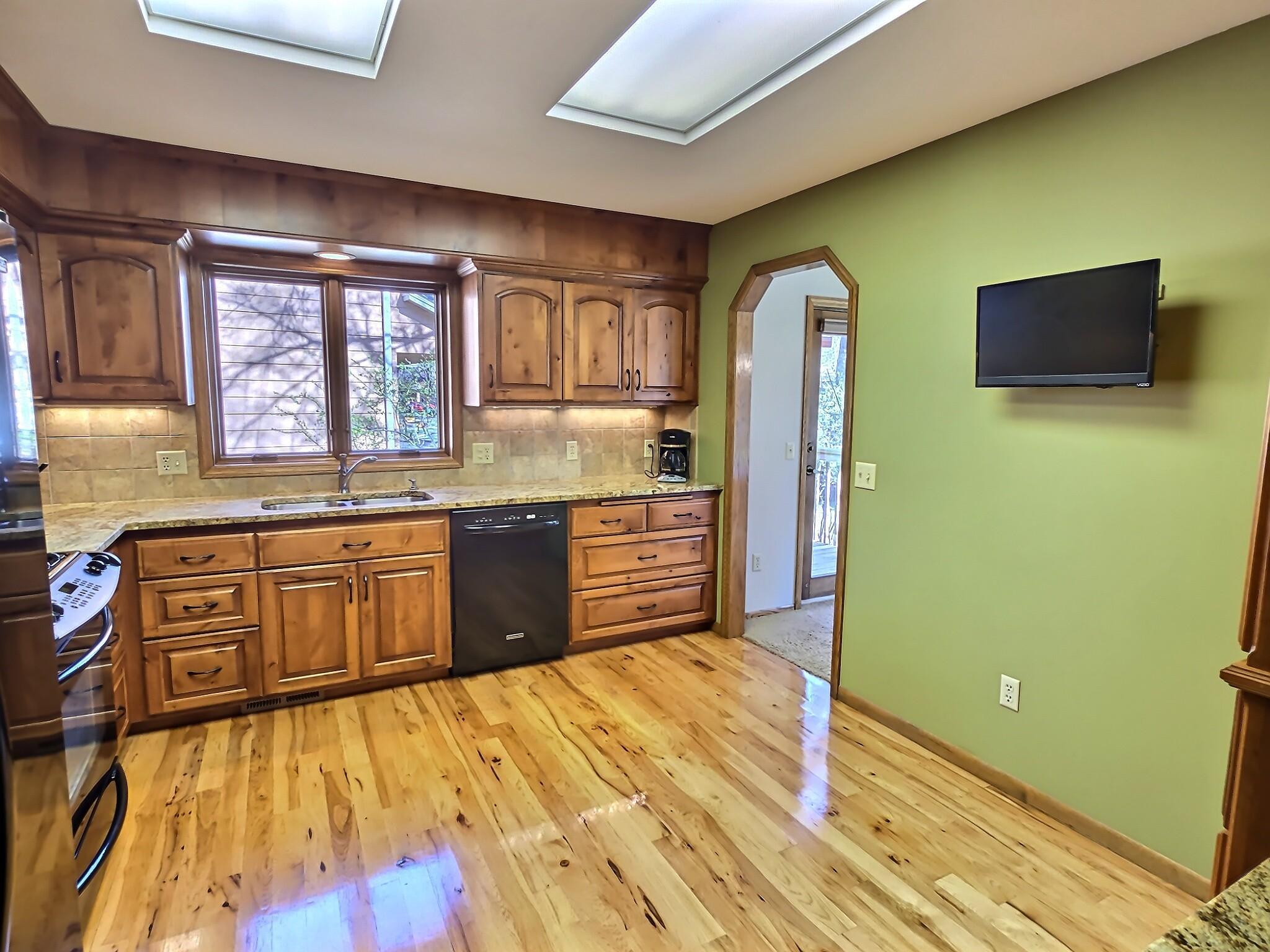 The cabinets are complemented by gleaming granite countertops, offering both durability and elegant contrast.