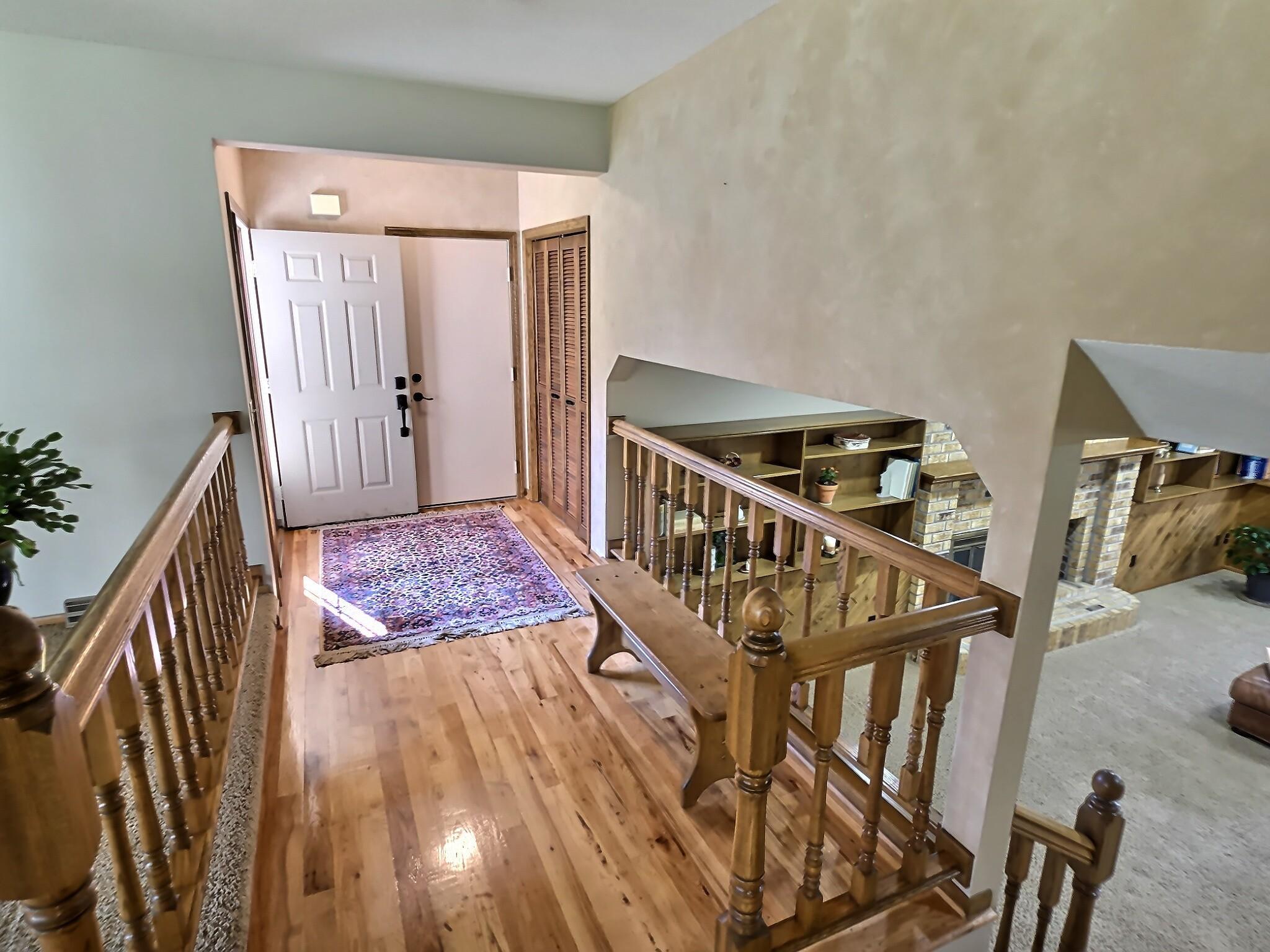 The inviting foyer meets you with natural sunshine that dances off the hickory wood floors and showcases the ample amount of space this area provides.