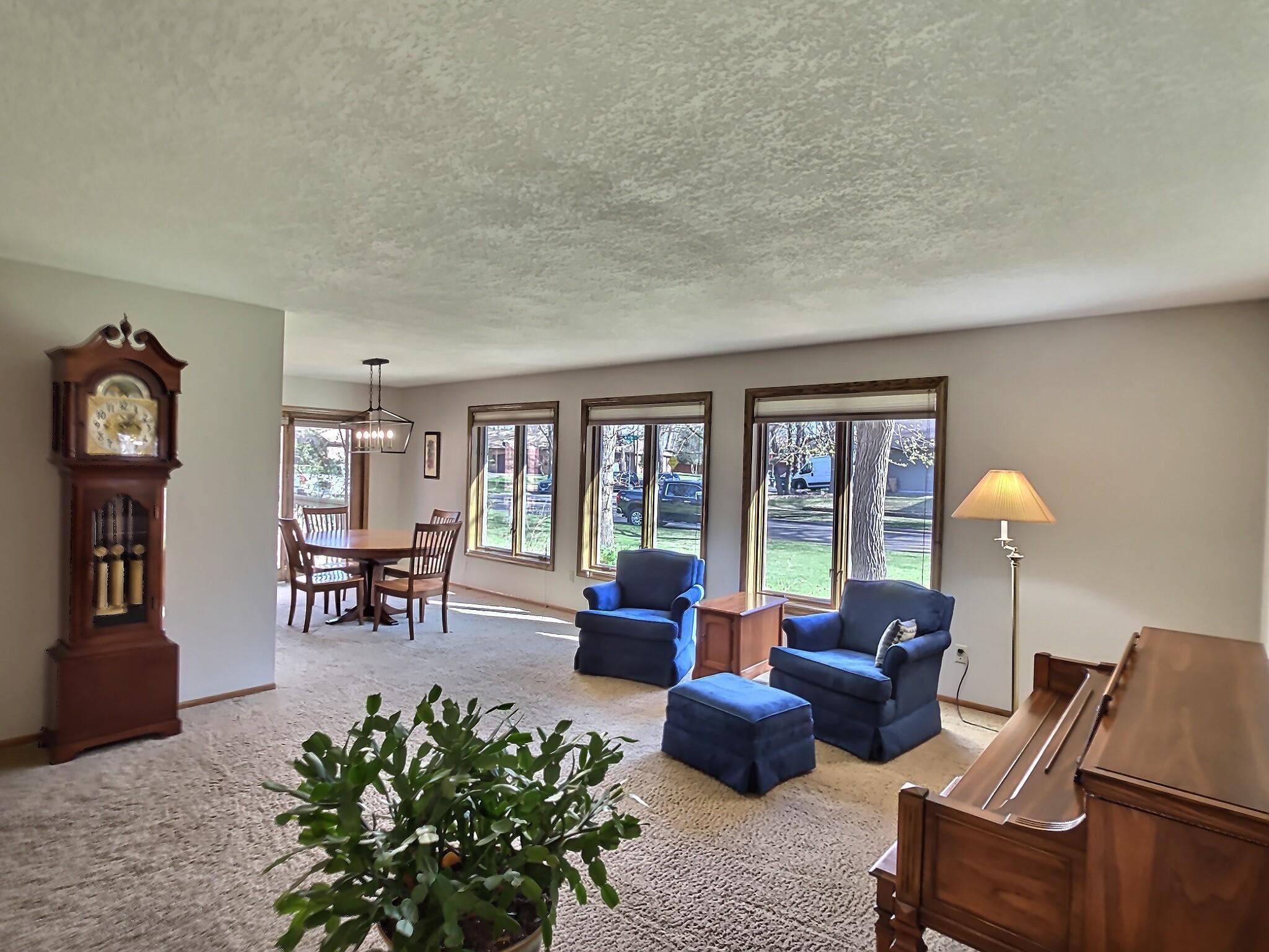 The sun-filled main level features an inviting living room, an open kitchen with ample workspace, and a dining area that leads to a relaxing deck—perfect for entertaining or quiet evenings.