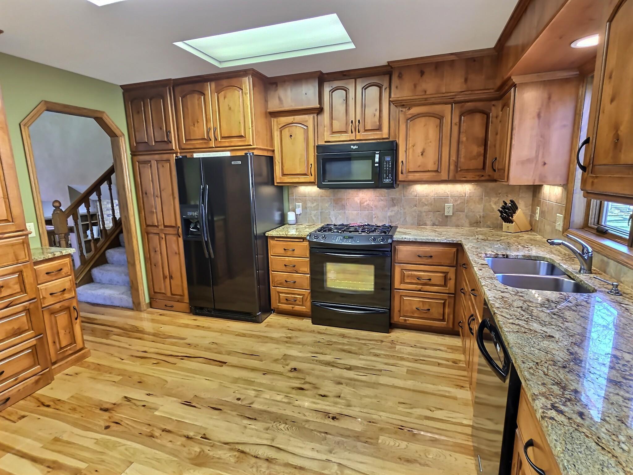 A beautifully remodeled kitchen with a warm, inviting feel, featuring rich knotty alder cabinetry that adds natural character and depth.