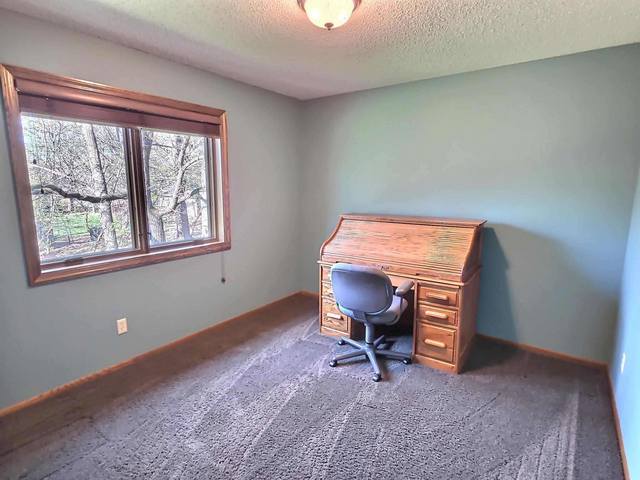 The third bedroom on the upper level includes carpet floors, wooden blinds and great views of the backyard.
