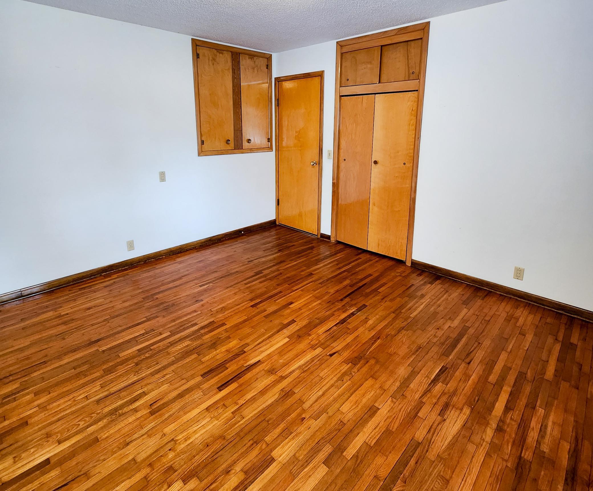 1st of three main floor bedrooms with hardwood floors and plenty of closet and storage.jpg