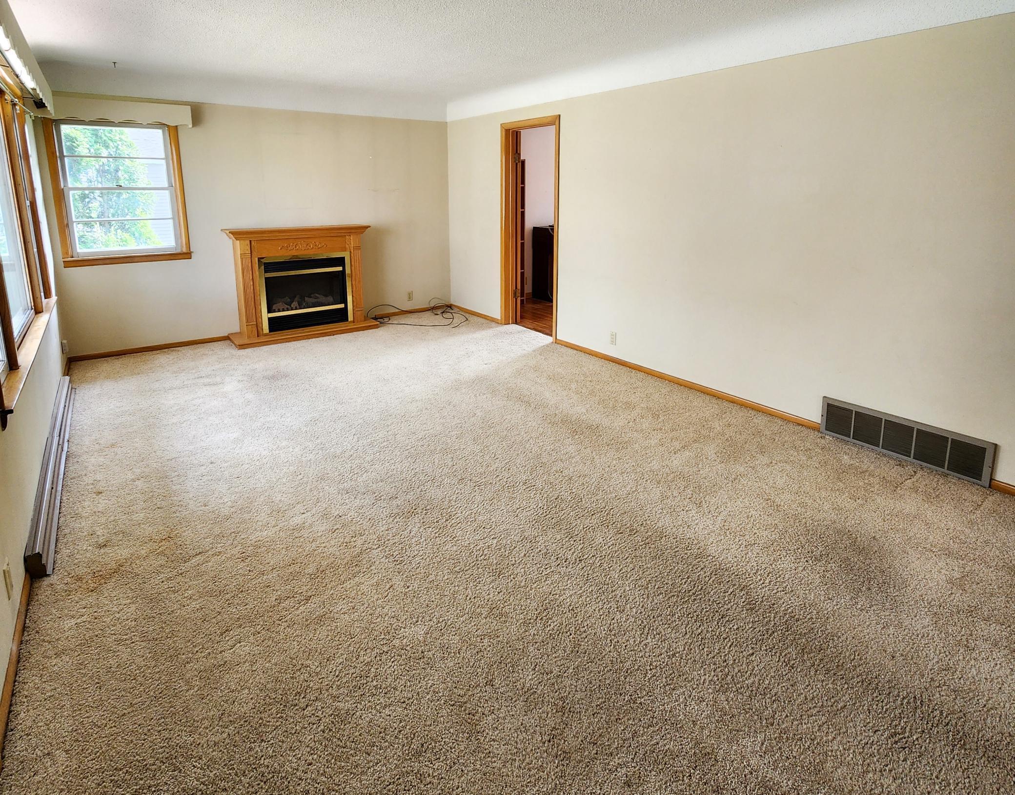 Large living room with coffered ceilings and large windows to let in that natural light. The fireplace does not work and will be removed.jpg