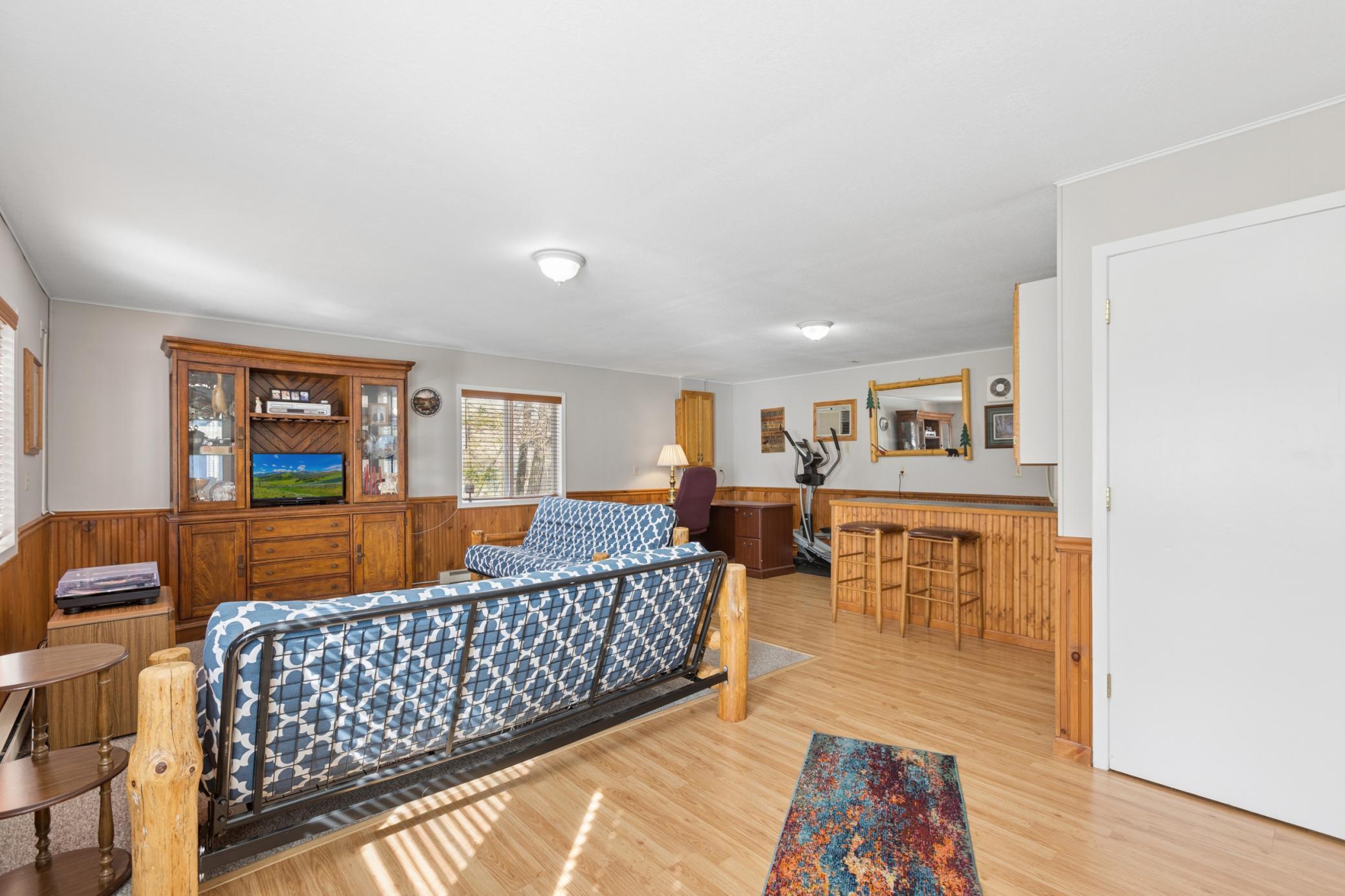 The bunk house entertaining space that is attached to the garage features electric baseboard heat and a wall unit AC. This space was previously used as a workshop but would also make for a great home office.