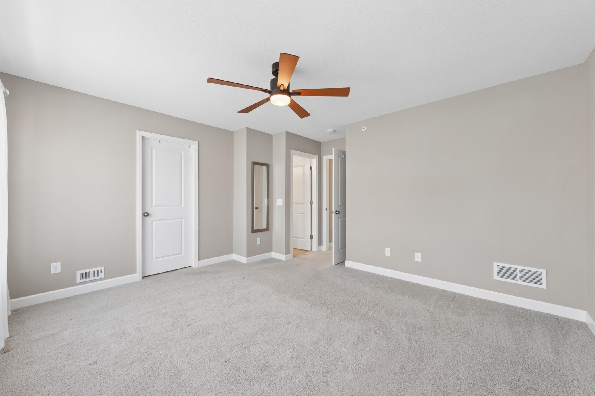 Looking back in primary bedroom towards walk in closet and full private bath