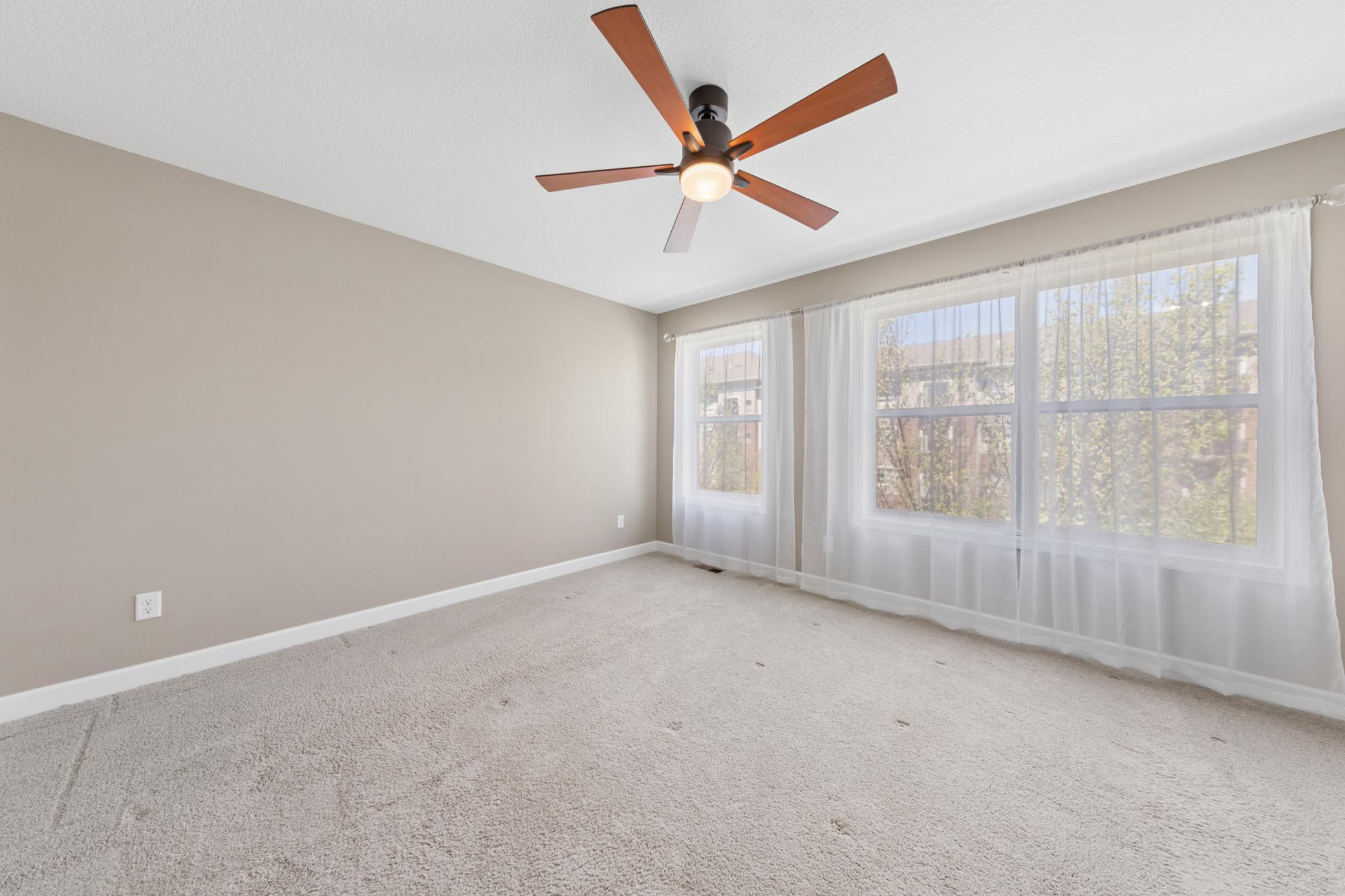 Large primary bedroom with ceiling fan
