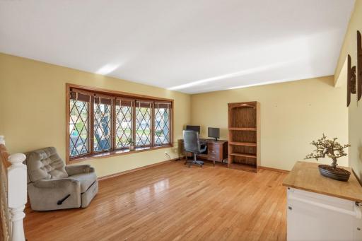 The upper level features gleaming hardwood floors and abundant natural light streaming through the large window.
