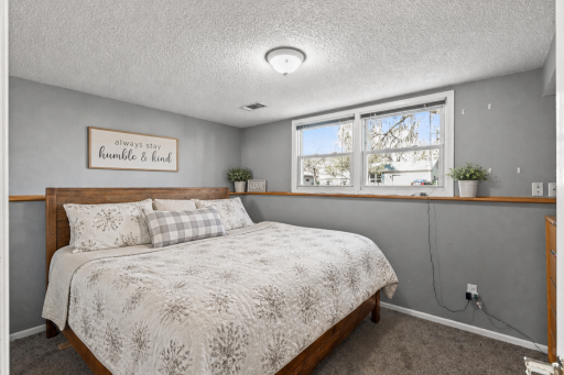 Third bedroom, located on the lower level, offers plush carpeting and neutral tones.