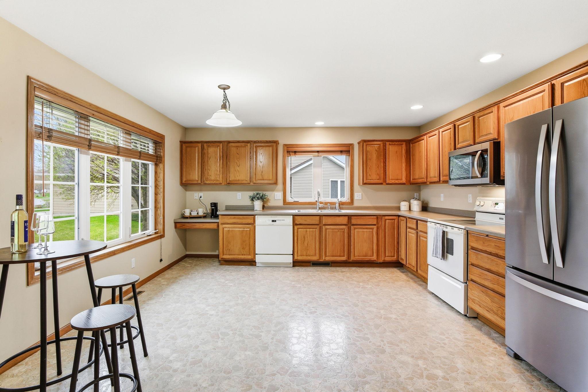 Large kitchen with plenty of cabinet space, room for an eat-in dining area, and updated stainless steel refrigerator and microwave.