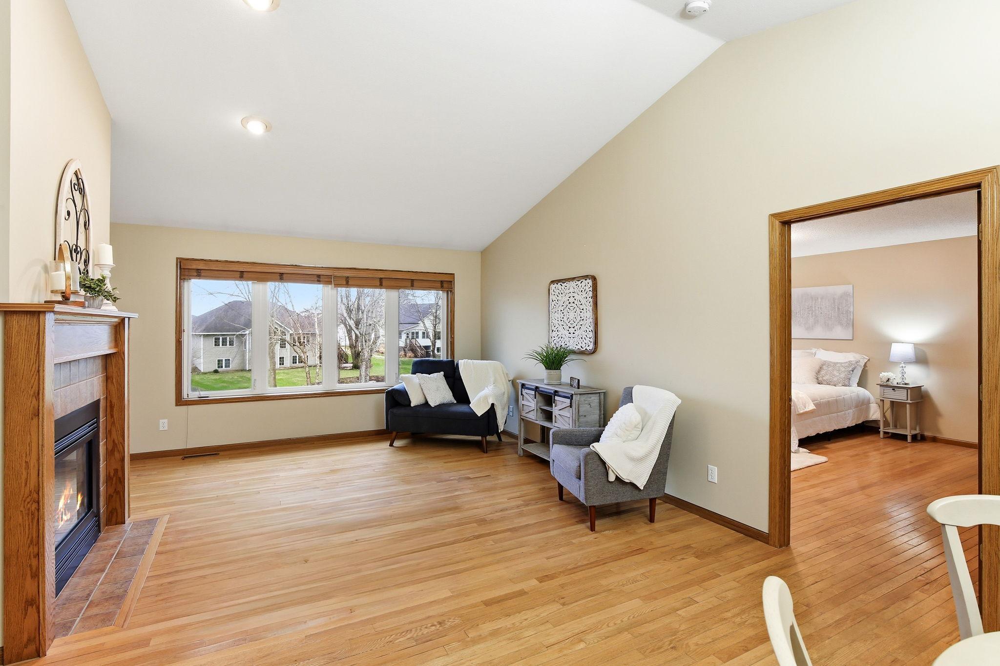 Vaulted living room with large windows and a gas see-through fireplace as a central feature.
