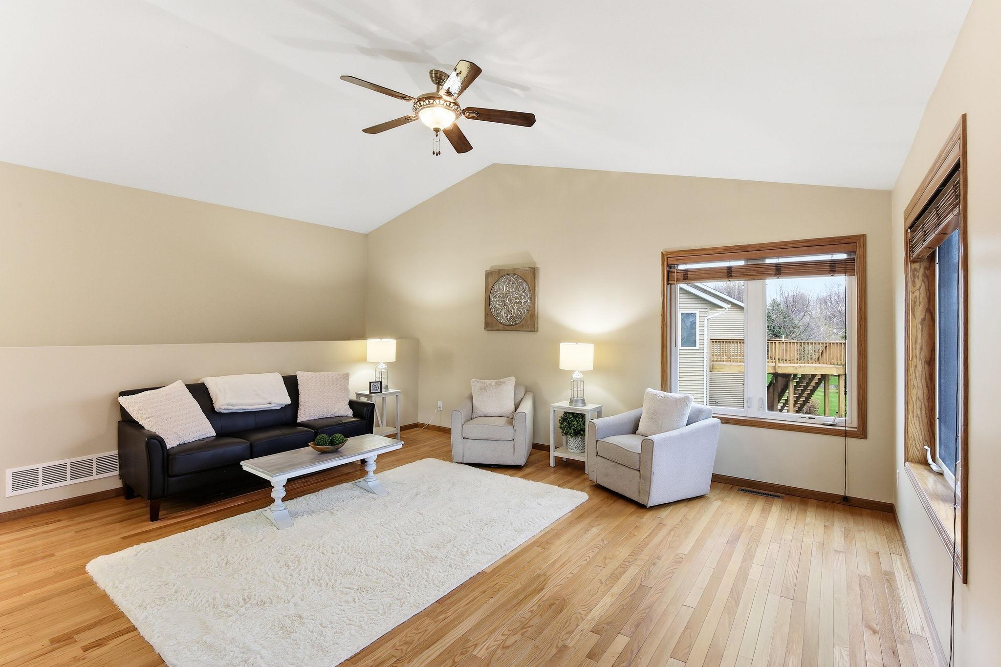 Spacious great room with vaulted ceiling, hardwood floors, and plenty of natural light.