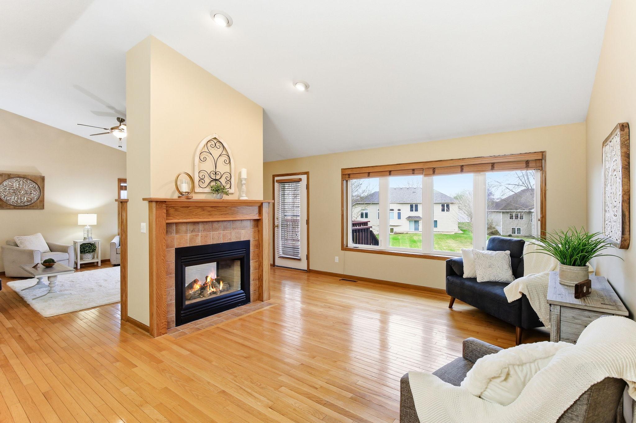Great room with hardwood floors and open sightlines, centered around the fireplace and connected living spaces.