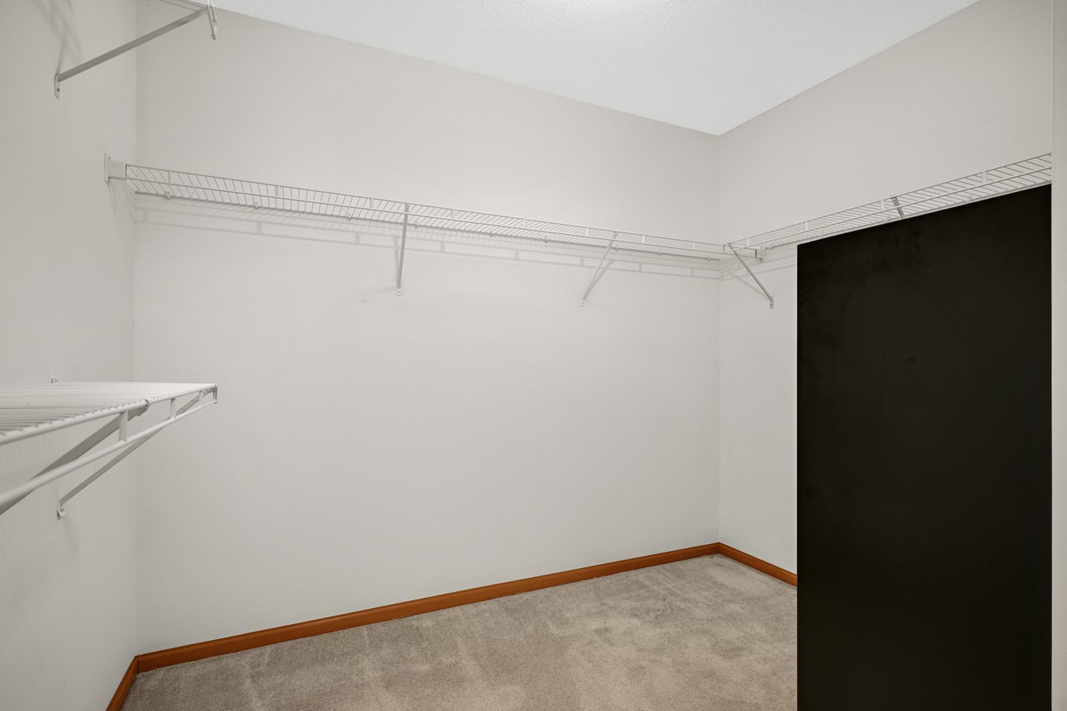 Large walk-in closet with built-in shelving for organized, efficient storage