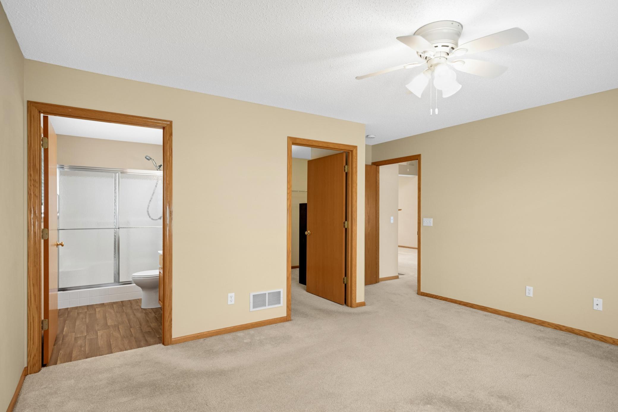 Primary bedroom featuring a private ensuite bathroom and spacious walk-in closet