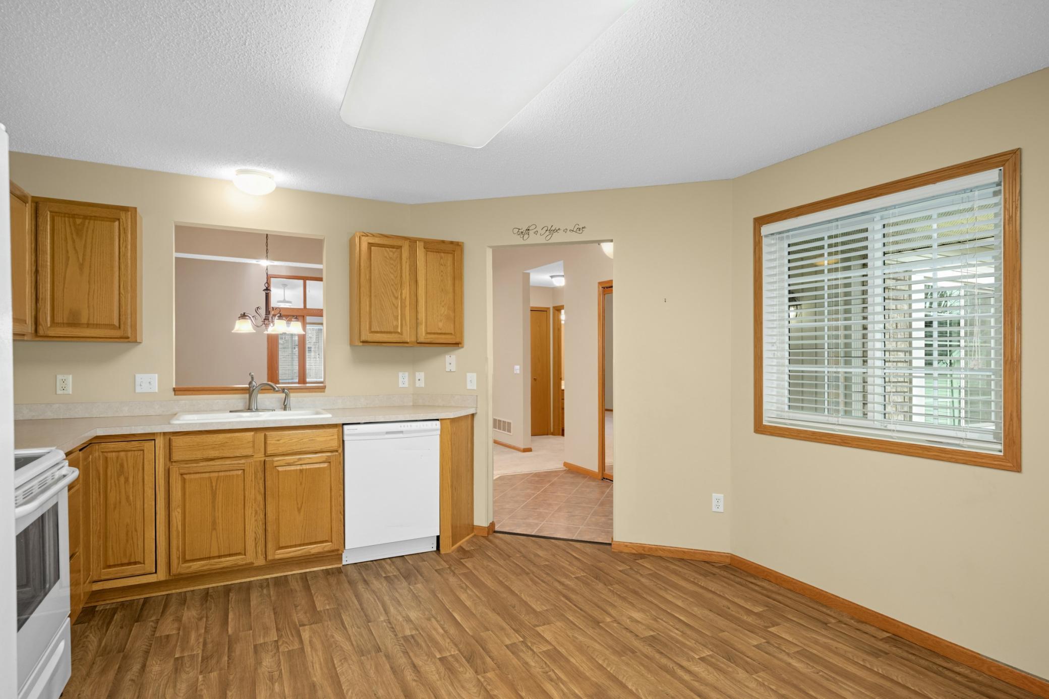Wall cutout above the kitchen sink offers open views into the dining and living areas, enhancing connection and light