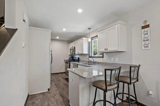 This kitchen features a range of desirable amenities, including counter seating, durable Silestone countertops, and abundant cabinetry with a dedicated pantry for added storage and organization.
