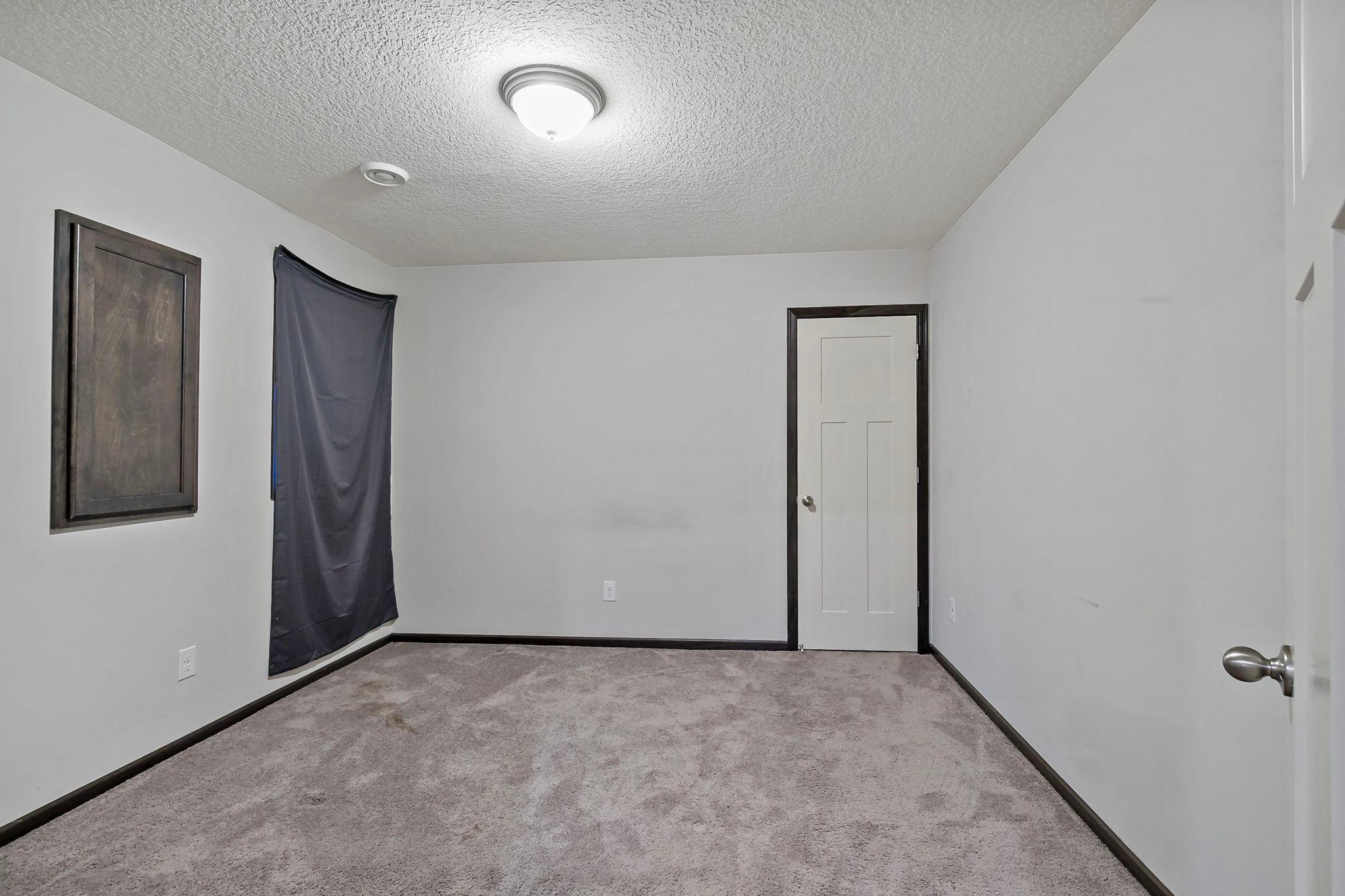 The lower-level bedroom includes an egress window for natural light and safety, along with a walk-in closet that provides excellent storage and functionality.