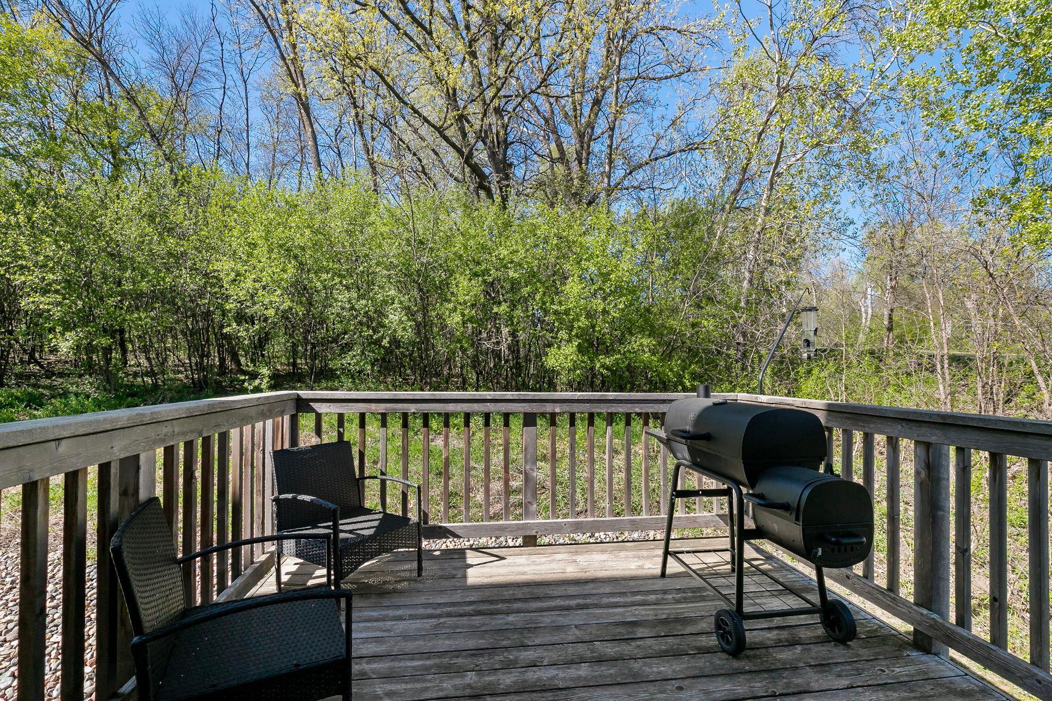 The deck also offers peaceful views of the wooded backdrop behind the property.