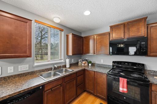 The kitchen is both functional and stylish, with hardwood floors and granite countertops.