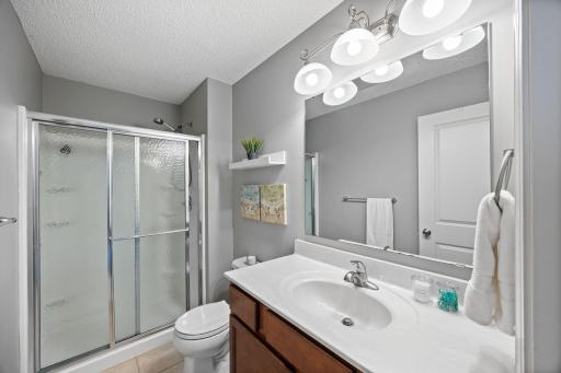 Private bathroom complete with tile flooring, vanity, and walk-in shower!