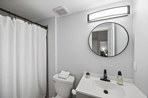 Nearby lower-level bathroom that includes a walk-in shower. Additional storage is thoughtfully tucked into a finished under-stair closet.