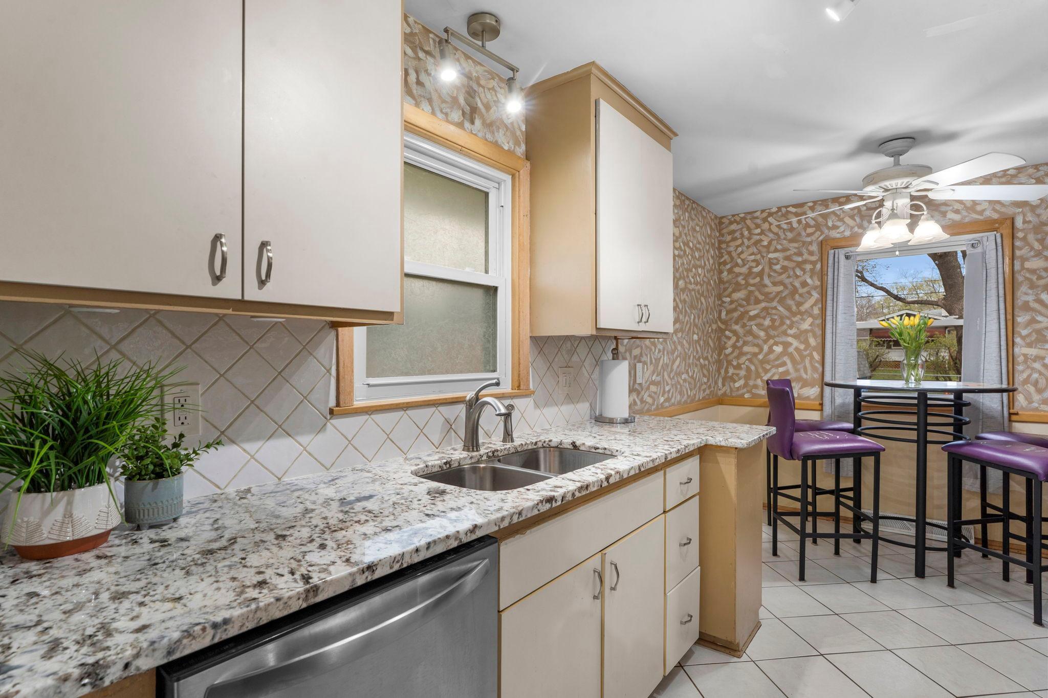 The kitchen is equipped with tile flooring and backsplash, updated granite countertops, and stainless steel appliances (2024).